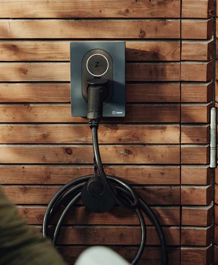Junger Mann mit Wallbox zum e-Auto laden